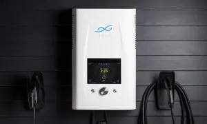Biała ładowarka do samochodów elektrycznych z ekranem dotykowym, obok niej wiszą kable. To zaawansowany silnik inwerterowy.