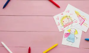 Dziecięce rysunki mamy i dziecka, kredki. Obrazek symbolizuje troskę i wsparcie, jak alimenty na dziecko.
