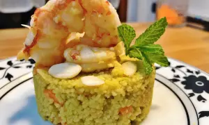 Un elegante cous cous gourmet con gamberi, mandorle e menta, un piatto raffinato.