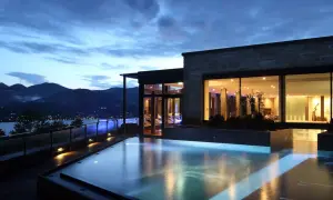 Ein luxuriöser Pool mit Blick auf die Berge und einen See. Perfekt für einen entspannten Urlaub in den Bergen.