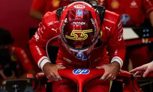 Carlos Sainz, piloto de Ferrari, se inclina sobre el volante de su monoplaza, con el casco rojo y el número 55.