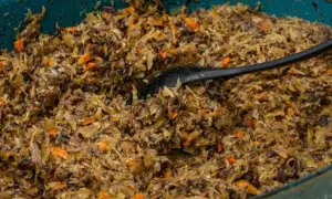 Pyszne, domowe pierogi z kapustą i grzybami, gotowe do podania. Czarna łyżka miesza aromatyczny farsz.