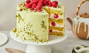 Ein köstlicher Pistazien Cheesecake mit frischen Himbeeren und gehackten Pistazien, bereit zum Servieren.
