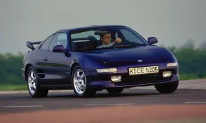 Mężczyzna prowadzi fioletowe Toyota MR2 SW20 po krętej drodze.