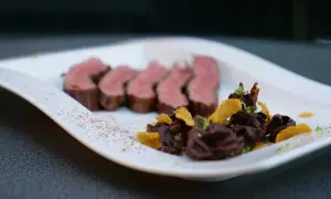 Saftiges Flank Steak, in Scheiben geschnitten, serviert mit dunkler Schokolade und knusprigen Chips.