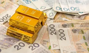 Sztabki złota na stosie polskich banknotów. Rozważasz sprzedaż złota i zastanawiasz się nad podatkiem?