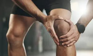 Sportler hält schmerzendes Knie, deutet auf eine mögliche Kreuzbandriss Schwellung hin.