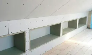 Zabudowa skosów na poddaszu z otwartymi wnękami, idealna na półki.