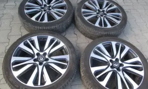 Cztery felgi aluminiowe Renault Initiale z oponami, gotowe do montażu.