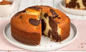 Torta al cioccolato senza burro, con un invitante effetto marmorizzato e una fetta tagliata che ne rivela la morbidezza.
