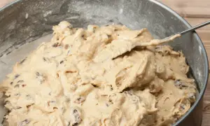 Ciasto na szybkie kruche ciasteczka z rodzynkami w tortownicy, gotowe do pieczenia.