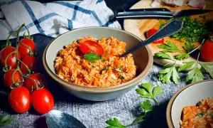 Ein einfacher Tomatenreis, garniert mit frischer Petersilie und Tomaten. Perfekt für ein schnelles und leckeres Abendessen.