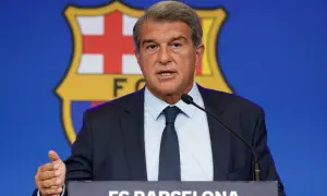 Prezydent FC Barcelona przemawia na tle herbu klubu, omawiając, ile Barcelona ma długu.