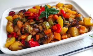 Un plat coloré de recette caponata sicilienne traditionnelle au four, avec des légumes rôtis et une touche de basilic frais.