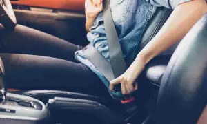 Persona abrochándose el cinturón de seguridad, un gesto esencial para la seguridad en la circulación vial.