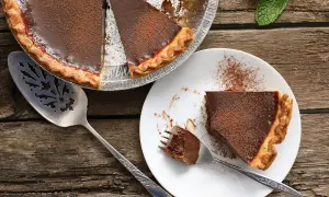 Une délicieuse tarte au chocolat, parfaite pour une recette gourmande. Une part est servie sur une assiette, prête à être dégustée.