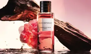 Flakon Dior Oud Ispahan otoczony wodą, różą i fragmentem drewna.