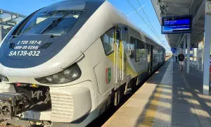 Pociąg SA139-032 na stacji, gotowy do odjazdu. Na tablicy informacyjnej widnieje kierunek Guben. Zielona góra łódź to symbol, który może kojarzyć się z podróżą.