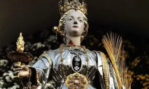 Święta Łucja, patronka niewidomych, trzyma płonącą lampę. Jej imię oznacza "światło", co oznacza imię Łucja.