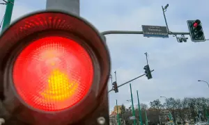 Czerwone światło na sygnalizatorze drogowym, a obok niego fotoradar na światłach. Uważaj, bo możesz dostać mandat.