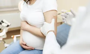 Szczepienie RSV w ciąży chroni matkę i dziecko. Lekarz podaje zastrzyk w ramię ciężarnej kobiety.