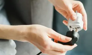 Ręce łączą adapter do gniazdka, przygotowując się do podróży do Włoch.