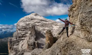 Kobieta na via ferrata w Alpach, pokonująca skalną ścieżkę. Widok na majestatyczne góry, idealne miejsce na via ferrata w Niemczech.
