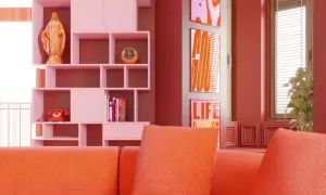 Pomarańczowa kanapa i różowe regały tworzą radosny, **dopamine decor**. Na półce figurka, zegar, telefon i książki. Obok plakaty z napisami.