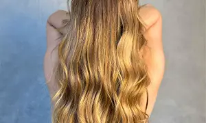 Długie, falowane blond włosy lśniące po olejowaniu na sucho.