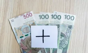 Polskie banknoty 500 i 100 zł. Na białej kartce symbol plusa, sugerujący, że 4200 brutto to dopiero początek.