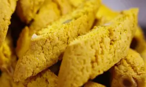 Närbild på gyllene saffransbiscotti med mandel, perfekta att doppa i kaffe.