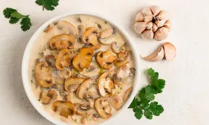Krämig svampgryta, perfekt för ett snabbt champinjoner recept. Serveras med vitlök och färsk koriander.