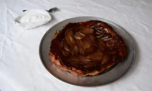 En gyllene lökpaj på en plåt, perfekt som lyxig mat att bjuda på. Serveras med en klick gräddfil.