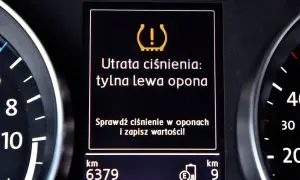 Komunikat na desce rozdzielczej: "Utrata ciśnienia: tylna lewa opona". Czujnik ciśnienia w oponach sygnalizuje problem.