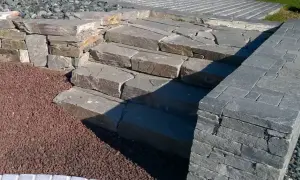 Kamienne schody i murek z kamienia łupanego tworzą naturalny element ogrodu.