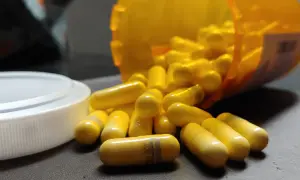 Gula kapslar, en del av en burk, ligger utspridda. En kapsel visar texten "gabapentin 300 mg", en medicin som kan hjälpa mot ångest.