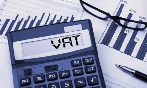 Kalkulator z napisem VAT, wykresy i okulary. Analiza zwolnienia podmiotowego z VAT.