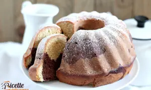 Un delizioso ciambellone bicolore, con cacao e vaniglia, spolverato di zucchero a velo, pronto per essere gustato.