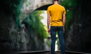 Man op spoor, omringd door groen. Een metafoor voor het navigeren door het leven met hsp, waar elke stap bewust gezet moet worden.