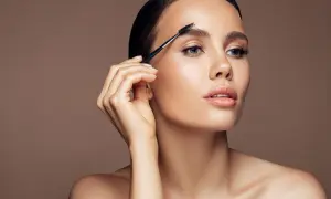 Kobieta czesze brwi szczoteczką do stylizacji.