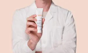 Mano sosteniendo un tubo de crema Avène Cicalfate+, ideal para piel irritada.