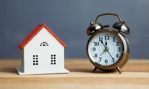 Model domu i budzik przypominają o ciszy nocnej w Polsce. Czas na odpoczynek.
