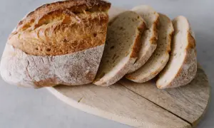 Chrupiący bochenek chleba, pokrojony na kromki, idealny do nauki, jak upiec chleb.