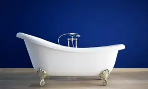 Elegancka, biała wanna wolnostojąca na ozdobnych nóżkach. Jej pojemność zachęca do relaksującej kąpieli.