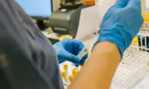 Laborant hanterar provrör i laboratoriemiljö, en del av forskningen kring anhedoni behandling.