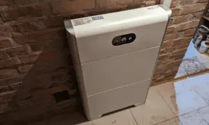 Biały magazyn energii 10kW, stojący przy ceglanej ścianie, to serce domowej instalacji fotowoltaicznej. Zastanawiasz się, na ile wystarczy energii z takiego magazynu?