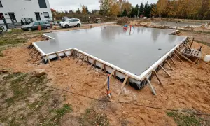 Solidne fundamenty pod dom parterowy wylewane na mokro. Płyta fundamentowa zbrojona i zaizolowana, gotowa na dalsze prace budowlane.
