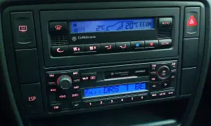 Klimatronik co to? Panel sterowania klimatyzacją i radiem w samochodzie. Widoczny wyświetlacz z temperaturą 20°C i przyciski.