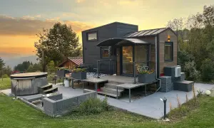 Tiny house dans le Jura, avec jacuzzi et mobilier extérieur, au coucher du soleil.