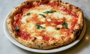 Eine authentische Pizza Margherita, wie sie in der Pizzeria Brandi in Neapel serviert wird, mit frischem Basilikum und geschmolzenem Mozzarella.